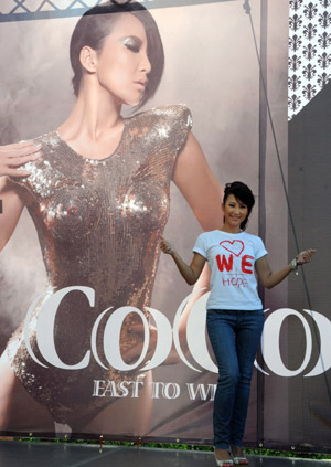 Pop singer Coco Lee attends a promotion event of her new album in Taipei, southeast China's Taiwan Province, Aug. 23, 2009, during which she raises donations for the typhoon Morakot hit area in Taiwan by rummage sales of T-shirts designed by herself with a designing group. [Wu Ching-teng/Xinhua]