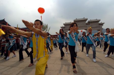 The contestants of Miss Tourism Queen International 2009 learn martial arts at the Shaolin Temple, central China's Henan Province, Aug. 23, 2009. [Qian Yi/Xinhua]