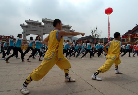 The contestants of Miss Tourism Queen International 2009 learn martial arts at the Shaolin Temple, central China's Henan Province, Aug. 23, 2009.[Qian Yi/Xinhua]