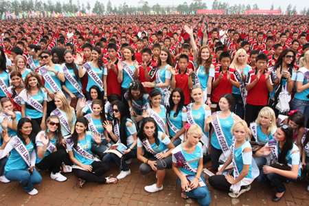 Contestants of Miss Tourism Queen International 2009 pose for photos with the students of Shaolin Temple Tagou Wushu School in Dengfeng, central China's Henan Province, Aug. 23, 2009. Contestants of Miss Tourism Queen International 2009 toured the Shaolin Temple on Sunday. [Chen Daishu/Xinhua]