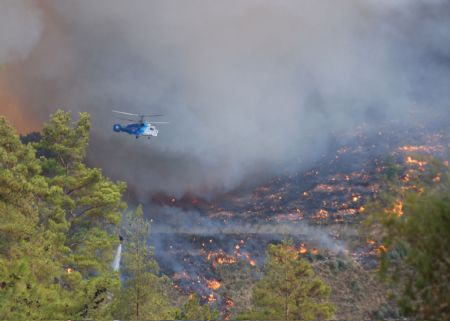 A water bomber sprays water to extinguish fire in Antalya, Turkey, August 24, 2009. As many as 150 hectares of forest have been affected so far by the raging fire in Antalya. [Anadolu Agency/Xinhua]