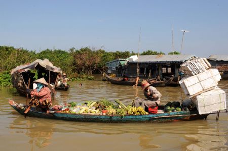 Local vendors sell vegetables and fruits on a boat on Tonle Sap Lake, northwest of Phnom Penh, capital of Cambodia, on Aug. 19, 2009.[Xinhua]