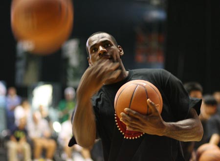 LeBron James of the Cleveland Cavaliers tosses basketballs to the audience at the end of a promotional event in Beijing August 24, 2009. James is in China on a worldwide tour to promote a product and to offer grass-roots basketball activities.(Xinhua/Meng Yongmin) 