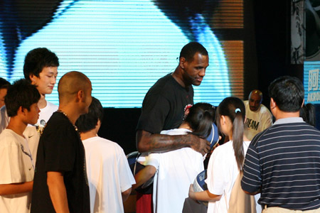 LeBron James of the Cleveland Cavaliers embraces a student from a school for children of migrant workers during a promotional event in Beijing August 24, 2009. (Xinhua/Meng Yongmin) 