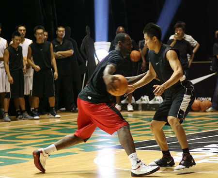 LeBron James of the Cleveland Cavaliers plays one-on-one with a fan during a promotional event in Beijing August 24, 2009. Xinhua/Meng Yongmin) 