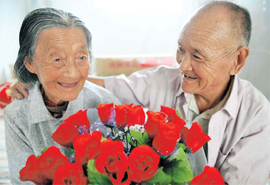 Han Rongxing, 79, gives roses to his 99-year-old wife, Zheng Qi'e, at a home for the elderly in Binzhou City, Shandong Province, yesterday on the eve of the Qixi Festival, Chinese Valentine's Day. Han and Zheng were married three years ago after meeting in the senior citizen facility. 