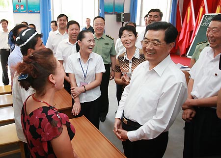 Chinese President Hu Jintao (R, front) talks with residents who are having a training course during an inspection at a community in Wensu County, Aksu, northwest China's Xinjiang Uygur Autonomous Region, on Aug. 22, 2009. Hu paid an inspection tour to the region from Aug. 22 to Aug. 25. [Ju Peng/Xinhua]