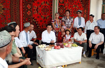 Chinese President Hu Jintao (C) talks with residents of Uygur ethnic group at a village in Aksu, northwest China's Xinjiang Uygur Autonomous Region, on Aug. 22, 2009. Hu paid an inspection tour to the region from Aug. 22 to Aug. 25. [Ju Peng/Xinhua] 
