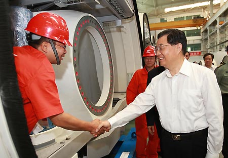 Chinese President Hu Jintao (R, front) shakes hands with a worker of Goldwind Science and Technology Co.,Ltd. in Urumqi, northwest China's Xinjiang Uygur Autonomous Region, on Aug. 23, 2009. Hu paid an inspection tour to the region from Aug. 22 to Aug. 25. [Ju Peng/Xinhua]