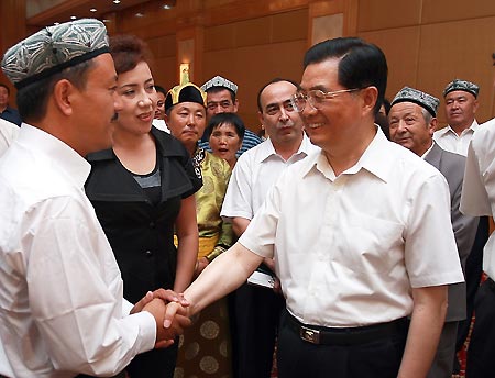 Chinese President Hu Jintao (R, front) meets with people who gave good performances to maintain social stability, local officials and religious representatives in Urumqi, capital of northwest China's Xinjiang Uygur Autonomous Region, on Aug. 23, 2009. Hu paid an inspection tour to the region from Aug. 22 to Aug. 25. [Ju Peng/Xinhua]