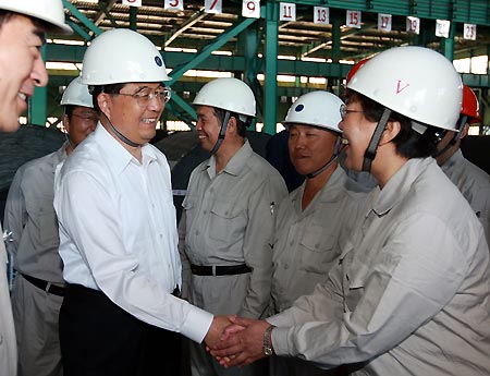 Chinese President Hu Jintao shakes hands with a worker of Baosteel Group Xinjiang Bayi Iron and Steel Co. Ltd. in Urumqi, capital of northwest China's Xinjiang Uygur Autonomous Region, on Aug. 23, 2009. Hu paid an inspection tour to the region from Aug. 22 to Aug. 25. [Ju Peng/Xinhua]