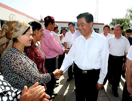 Chinese President Hu Jintao (front R) shakes hands with a local during an inspection at a community in Wensu County, Aksu, northwest China's Xinjiang Uygur Autonomous Region, on Aug. 22, 2009. Hu paid an inspection tour to the region from Aug. 22 to Aug. 25.[Xinhua]