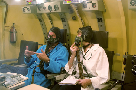 Guy Laliberte (L), Canadian billionaire owner of Cirque du Soleil and Barbara Barrett, his back-up crew member, sit in an altitude chamber as they prepare for exercises during a training session in the International Space Station (ISS) at the Star City space centre outside Moscow, August 17, 2009.[Xinhua/Reuters]