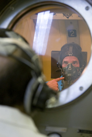 Guy Laliberte looks through the porthole of an altitude chamber as he prepares for exercises during a training session in the International Space Station (ISS) at the Star City space centre outside Moscow, August 17, 2009.[Xinhua/Reuters] 