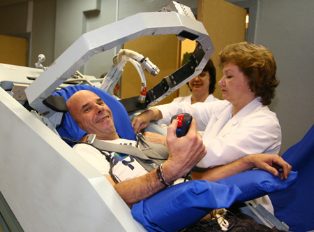  Guy Laliberte (L) prepares for exercises in a centrifugal machine as he attends a training session in the International Space Station (ISS) at the Star City space centre outside Moscow August 14, 2009.[Xinhua/Reuters]