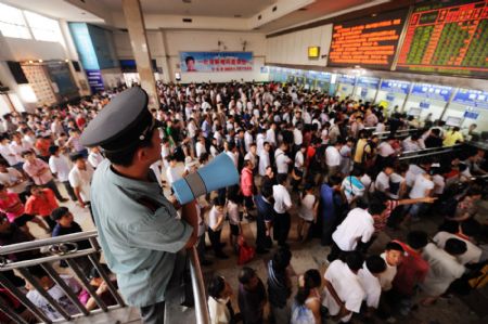 Passengers wait to buy train tickets at Changsha Railway Station in Changsha, central China's Hunan Province, on Aug. 25, 2009. Changsha Railway Station has witnessed a travel peak since more and more students began to return to schools after the summer vacation. [Long Hongtao/Reuters]