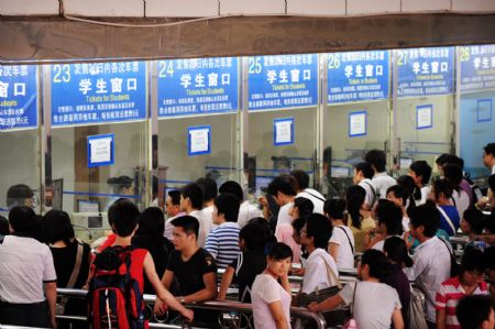 Students returning to schools wait in line to buy train tickets at Changsha Railway Station in Changsha, central China's Hunan Province, on Aug. 25, 2009. Changsha Railway Station has witnessed a travel peak since more and more students began to return to schools after the summer vacation. [Long Hongtao/Reuters]