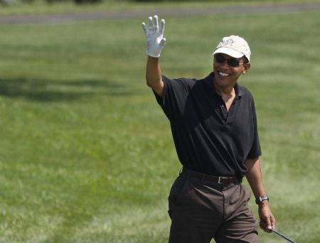 U.S. President Barack Obama waves to bystanders following his tee shot on the first hole during a round at Farm Neck Golf Course at Oak Bluffs on Martha's Vineyard, Massachusetts, August 24, 2009.[Xinhua/Reuters]