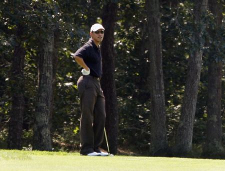 U.S. President Barack Obama stands on the first fairway as he waits for another member of his group to play their second shot during a round of at Farm Neck Golf Course at Oak Bluffs on Martha's Vineyard, Massachusetts, August 24, 2009. [Xinhua/Reuters] 