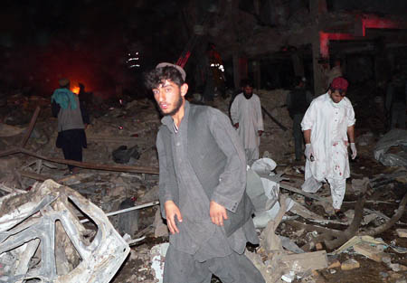 Afghan men are pictured on the site of a bomb blast in Kandahar city. A massive bomb ripped through the downtown area of the troubled Afghan city of Kandahar, killing up to 36 people and wounding dozens near hotels and government offices, officials said.
