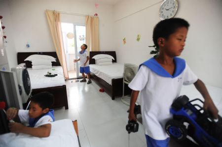 Children play in a dormitory of Xintanghu elementary school in Shuangliu, a county of southwest China's Sichuan Province, Aug. 26, 2009. China has built the country's first special complex of new apartment buildings and schools for orphans and children of needy families in the quake-hit Sichuan Province.