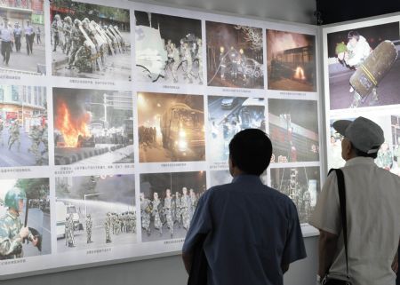 People visit an exhibition on the July 5 riot in Urumqi, at the Cultural Palace of Nationalities in Beijing, Aug. 26, 2009.(Xinhua/Chen Shugen)