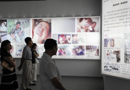  People visit an exhibition on the July 5 riot in Urumqi, at the Cultural Palace of Nationalities in Beijing, Aug. 26, 2009.(Xinhua/Chen Shugen) 