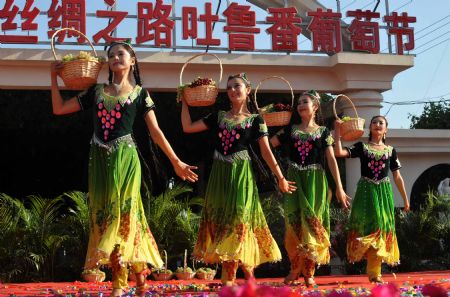 Girls perform during the opening ceremony of the 18th Grape Festival of Turpan on China's Silk Road, in Turpan, northwest China's Xinjiang Uygur Autonomous Region, Aug. 26, 2009. The festival since 1990 includes singing and dancing galas, symposiums on Silk Road tourism and on China's grape cultivation, cuisine contests for local snacks, and trade fairs as well.[Zhao Ge/Xinhua]