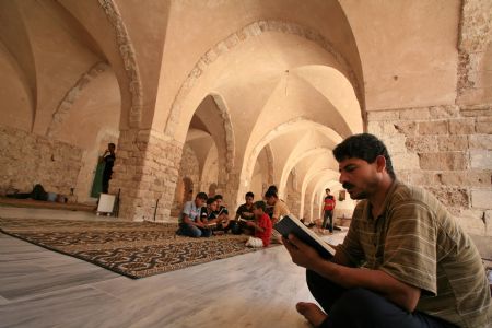 Palestinian people read the Koran during the holy fasting month of Ramadan in Al-Omari mosque in Gaza City on Aug. 26, 2009. [Wissam Nassar/Xinhua]