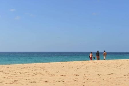 Tourists walk along a beach in Fernando de Noronha Island, northeastern Brazil, Aug. 25, 2009. Fernando de Noronha, well-preserved with its beautiful view, pure seawater and various marine lives, was listed as a world natural heritage site by the UNESCO in 2001. [Song Weiwei/Xinhua] 