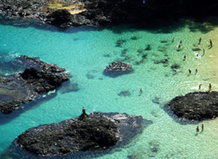 Tourists enjoy themselves in the sea near Fernando de Noronha Island, northeastern Brazil, Aug. 25, 2009. Fernando de Noronha, well-preserved with its beautiful view, pure seawater and various marine lives, was listed as a world natural heritage site by the UNESCO in 2001.[Yang Limin/Xinhua]