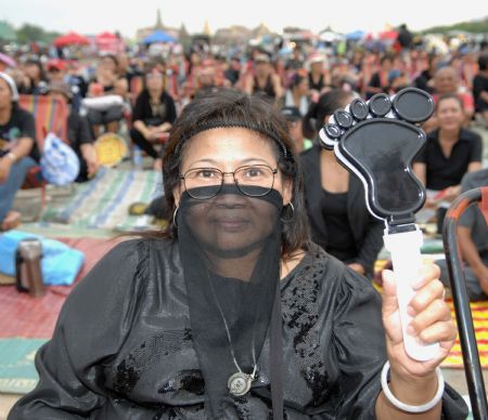 A 'red-shirted' woman, or the anti-government protestor, wearing black shirt attends a rallyat Sanam Luang in central Bangkok, capital of Thailand, on Aug. 26, 2009.[Xinhua]