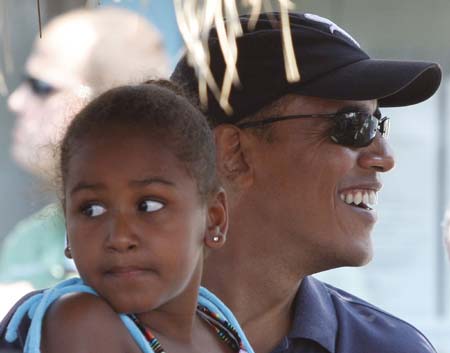 U.S. President Barack Obama and his daughter Sasha sit at Nancy's Restaurant as they wait to collect a take out order of lunch in Oak Bluffs, Martha's Vineyard, August 26, 2009. 