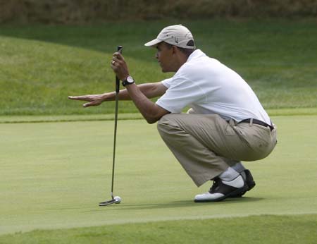 U.S. President Barack Obama lines up a putt on the final hole during a round of golf at the Mink Meadows Golf Club on Martha's Vineyard, August 25, 2009.