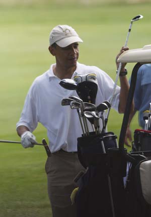 U.S. President Barack Obama puts away his clubs on the final hole during a round of golf at the Mink Meadows Golf Club on Martha's Vineyard, August 25, 2009.