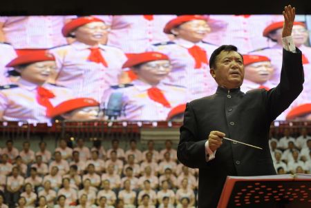 Local musician directs chorus during a celebration to greet the coming 60th anniversary of the founding of the People Republic of China in Urumqi, capital of northwest China's Xinjiang Uygur Autonomous Region on Aug. 27, 2009.(Xinhua/Wang Fei)