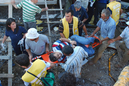 An injured man is carried away from the site of a train crash in Bilecik Province, northwestern Turkey, on Aug. 27, 2009. [Anatolia/Xinhua]