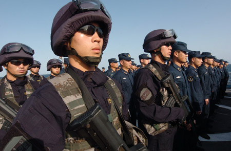 Chinese naval soldiers and officers of the Chinese escort flotilla attend the starting ceremony of the 100th escort mission on Zhoushan missile frigate in the eastern waters of the Gulf of Aden, Aug. 27, 2009. [Xinhua]