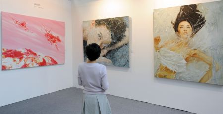 A visitor views Chinese artists' paintings at Taipei World Trade Center in Taipei, southeast China's Taiwan Province, Aug. 27, 2009. The Art Taipei 2009, which attracts artists from countries and regions such as China, Japan, South Korea, Finland, and Poland, will open here on Friday. It is said that the income of ticket selling and art work charity sale will be donated to the area hit by typhoon Morakot in Taiwan. (Xinhua/Wu Ching-teng)