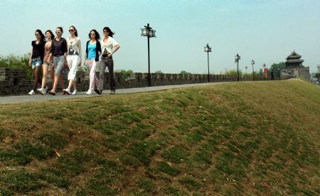 Young women walk on the ancient city-wall in Shouxian County, a famous historic and cultural site in east China's Anhui Province, on May 13, 2009.(Xinhua/Tao Ming)