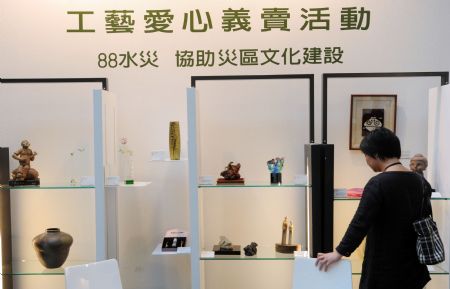 A woman stands by the craftwork at the charity sale zone on the Craft Taiwan 2009 in Taipei, southeast China's Taiwan Province, Aug. 27, 2009. The Craft Taiwan 2009 will open to the public on Friday with over 100 craftwork from nearly 60 artists on shown. The income of charity sale during the Craft Taiwan 2009 will be donated to the area hit by typhoon Morakot in Taiwan. [Xinhua/Wu Ching-teng]