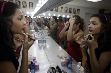 A girl applies makeup at a modelling school in Caracas August 27, 2009.(Xinhua/Reuters Photo)