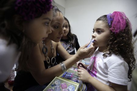 A girl has makeup applied on her face at a modelling school in Caracas August 27, 2009.(Xinhua/Reuters Photo)