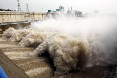 All sand-clearing sluices of the Gezhouba Dam on the Yangtze River are thoroughly opened to discharge and flush away the sand sediments on the Sanjiang Sail Routes in Yichang, central China's Hubei Province, Aug. 27, 2009. The maximal discharging volume reached as high as 9,000 cubic meters per second.