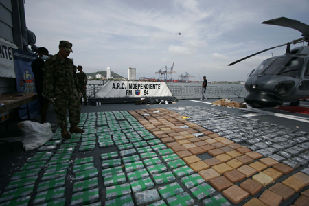 Soldiers stand guard beside some cocaine packs confiscated near Cartagena, port city in northern Colombia, Aug. 28, 2009. Colombian Marines Corps captured 553 kilograms of cocaine here on Friday.