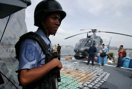 A soldier stands guard beside some cocaine packs confiscated near Cartagena, port city in northern Colombia, Aug. 28, 2009. Colombian Marines Corps captured 553 kilograms of cocaine here on Friday.