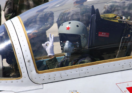 He Xiaoli, a female jet fighter pilot, gestures in the plane at an airport in north China, Aug. 30, 2009. The Chinese air force held Sunday a ceremony here for the first batch of female jet fighter pilots to be equipped with new flight suits especially designed for the female.(Xinhua/Zha Chunming)