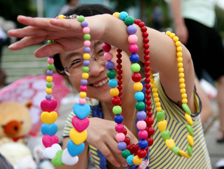 A woman shows her colour accessories for trade at a flea market kicked off on Saturday in the downtown of Nanjing, east China's Jiangsu Province, August 29, 2009. The flea market, the first one of its kind in the city, was organized to save and recycle various resources.