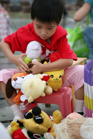A boy shows his colourful toys for trade at a flea market kicked off on Saturday in the downtown of Nanjing, east China's Jiangsu Province, August 29, 2009. (Xinhua Photo)