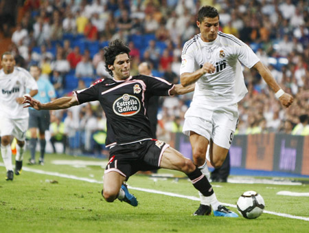 Real Madrid's Cristiano Ronaldo (R) dribbles in front of Deportivo Coruna's Angel Lafita during their Spanish first division soccer match at Santiago Bernabeu stadium in Madrid August 29, 2009. (Xinhua/Reuters Photo)